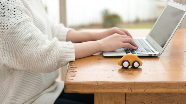 車とパソコン作業する人